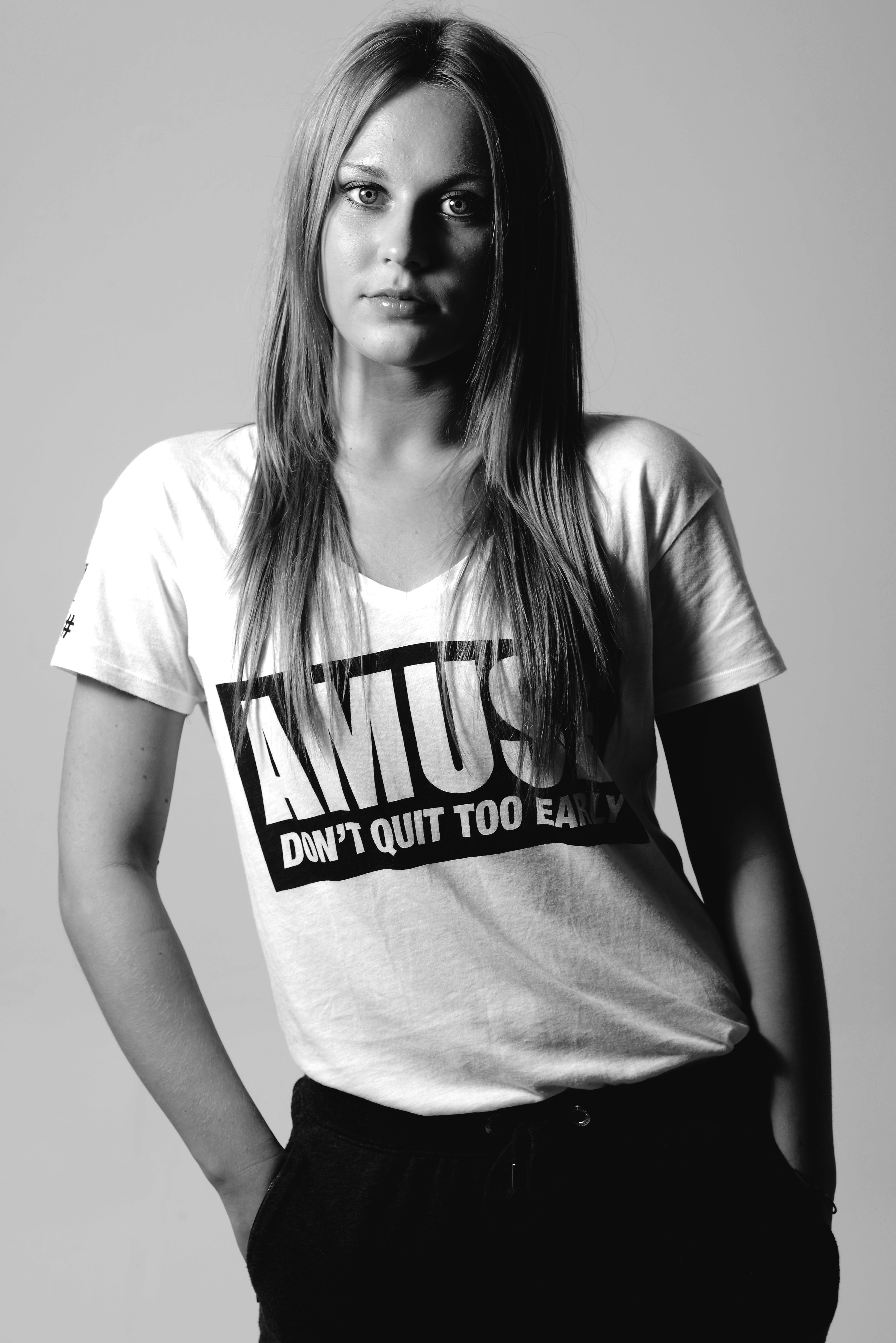 Black and white portrait of a young woman wearing a slogan T-shirt.