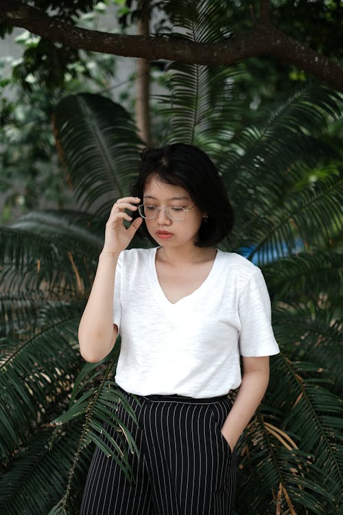 Photo Of Woman Standing Behind Palm Plant