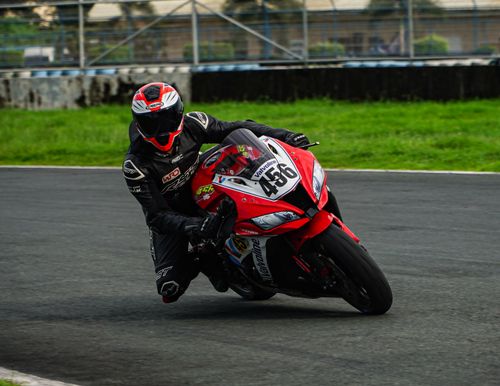 Free Dynamic shot of a motorcycle racer skillfully maneuvering a sharp turn on a track in Mabalacat, Philippines. Stock Photo