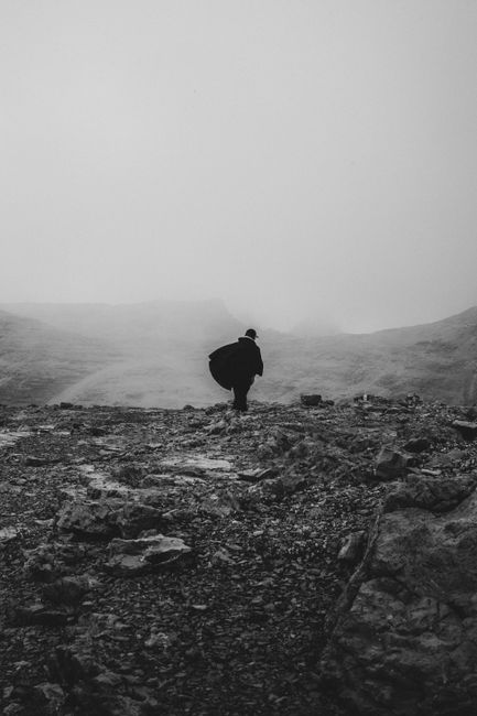 A solitary figure walks through a misty, rocky landscape in Trentino-Alto Adige, Italy.