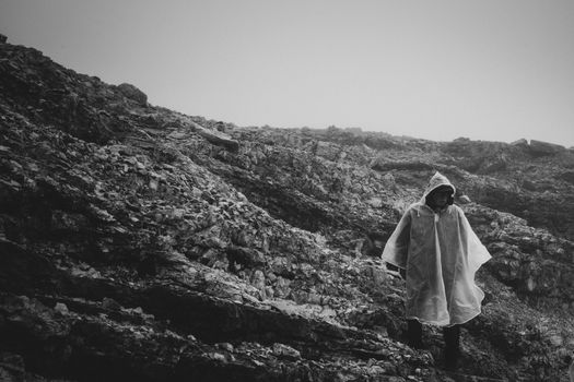 A person trekking in a misty, rocky landscape in Trentino-Alto Adige.