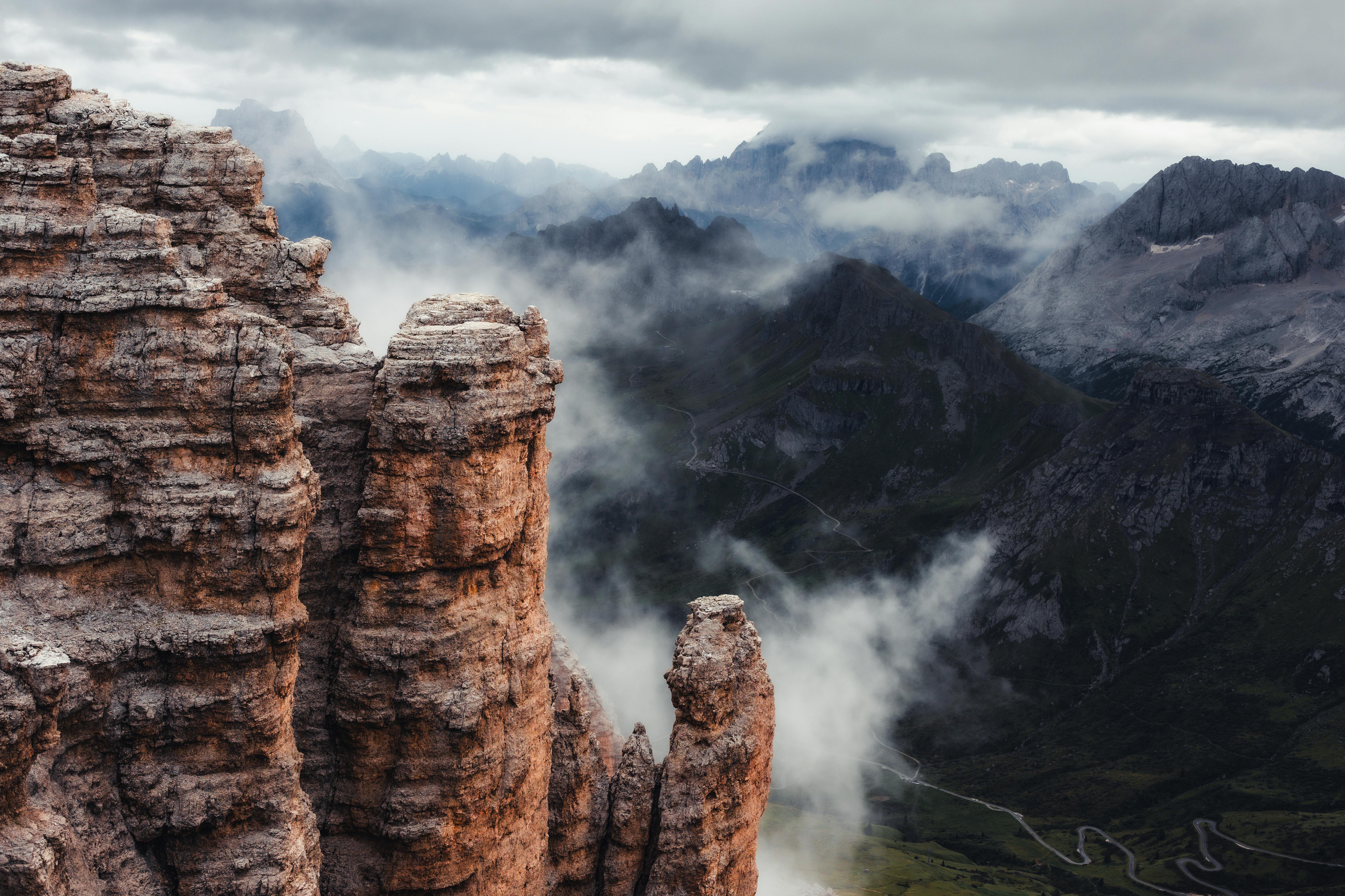 Breathtaking view of the Dolomites with towering peaks surrounded by mist and clouds.