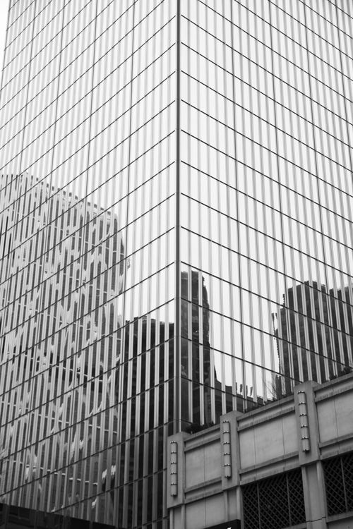 Free Black and white photo of skyscraper glass facade in New York City reflecting urban skyline. Stock Photo
