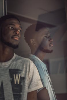 年轻人穿着时尚的服装，以严肃的外表在室内留下倒影