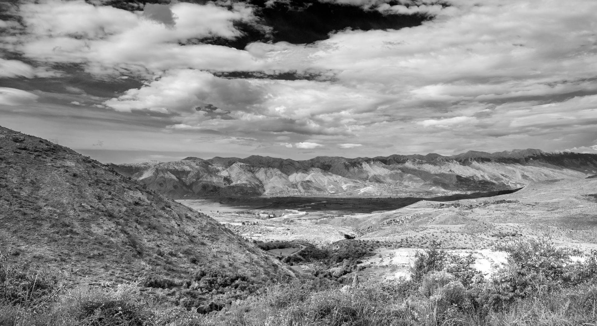A breathtaking black and white view of the Albanian mountains under a dramatic sky.