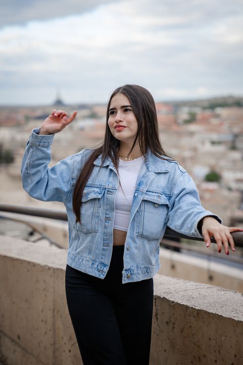Free Stylish young woman in denim posing confidently with urban background. Stock Photo