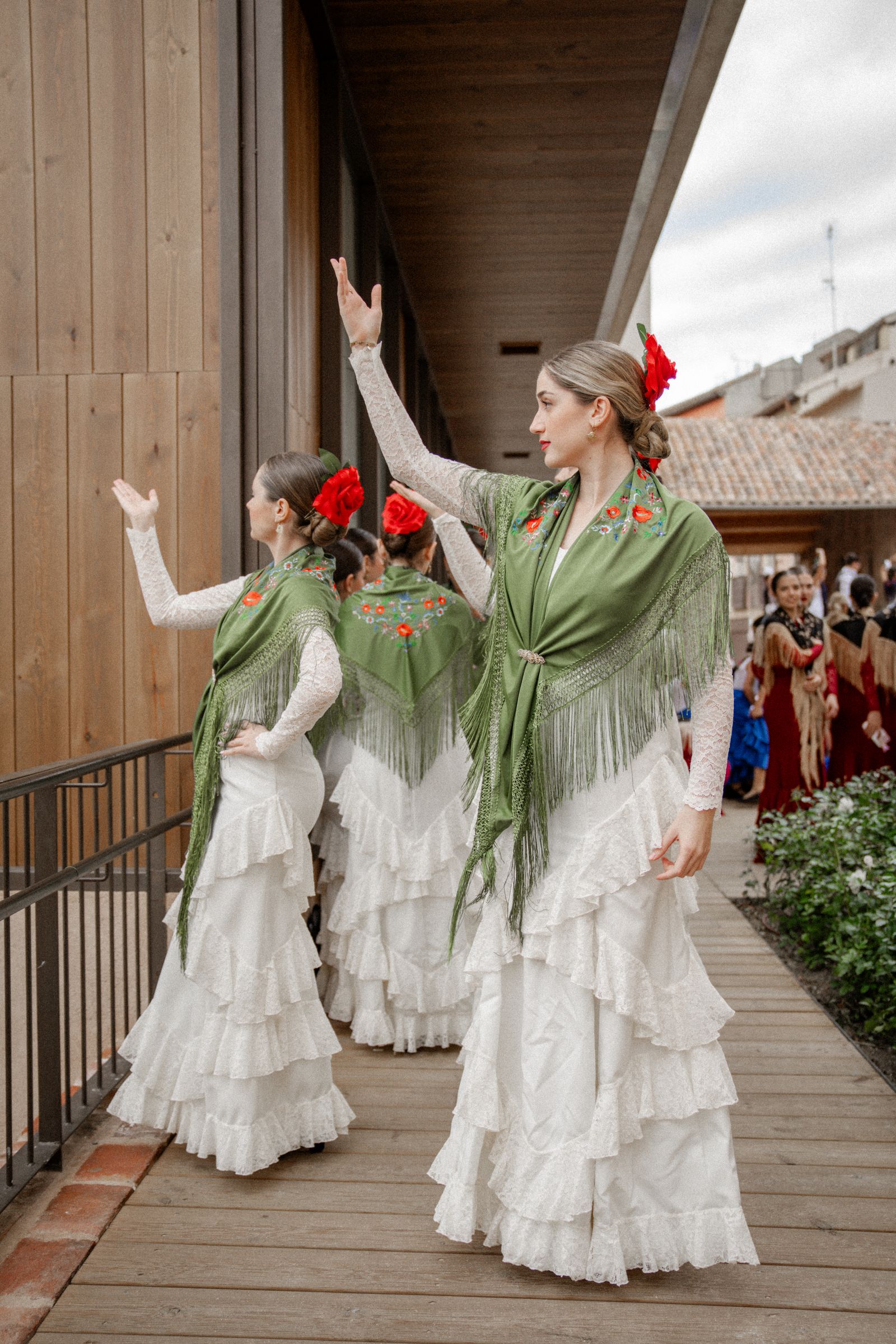 Women dancing sevillanas in flamenco dresses