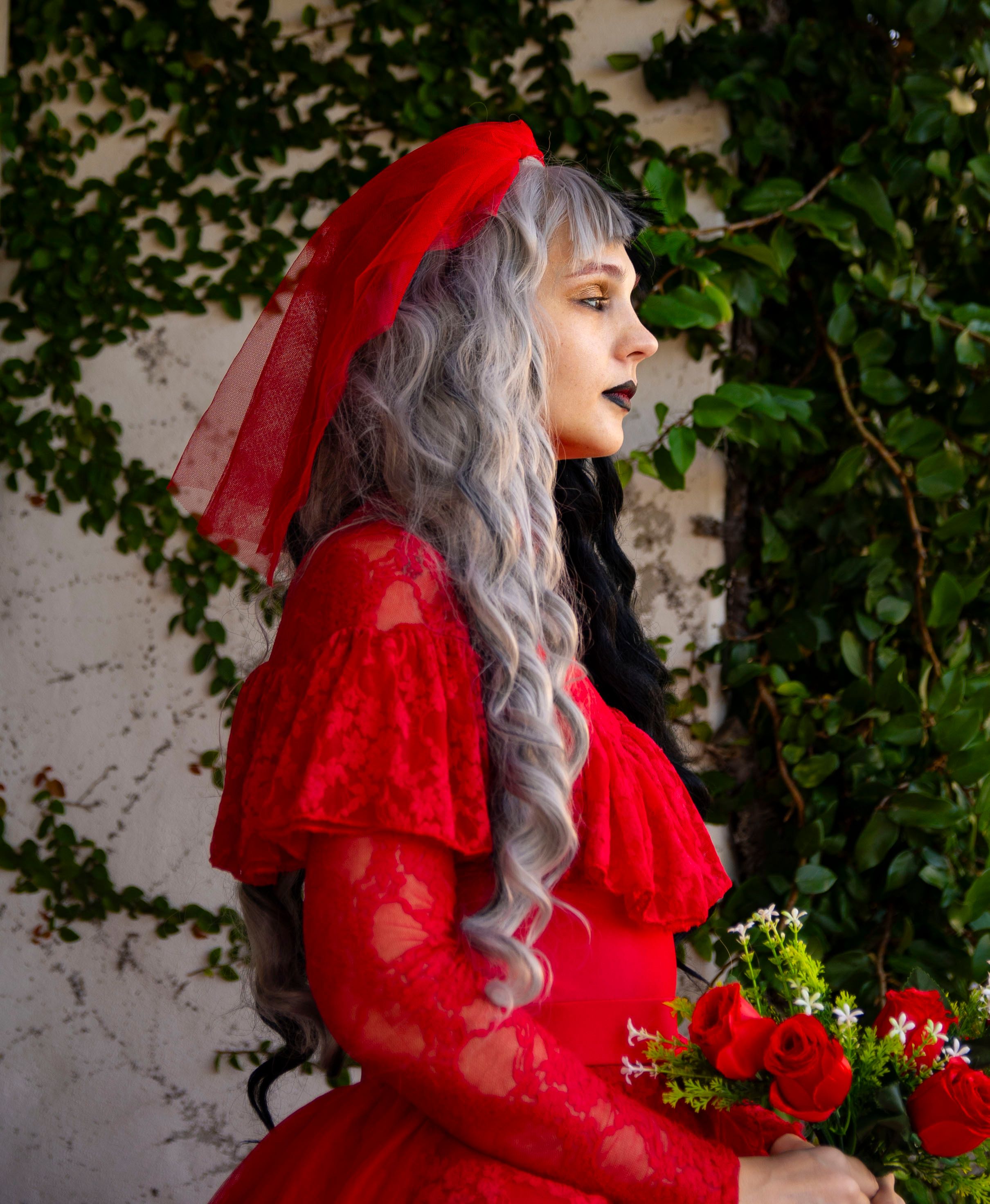 Elegant Woman in Red Gown Holding Roses · Free Stock Photo