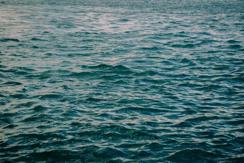 Free A calming view of ocean waves at sunset, showcasing natural beauty and tranquility. Stock Photo