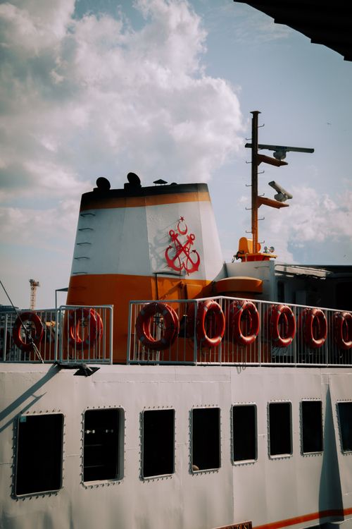 Free Close view of a ferry chimney adorned with lifebuoys under a bright sky, showcasing maritime travel. Stock Photo