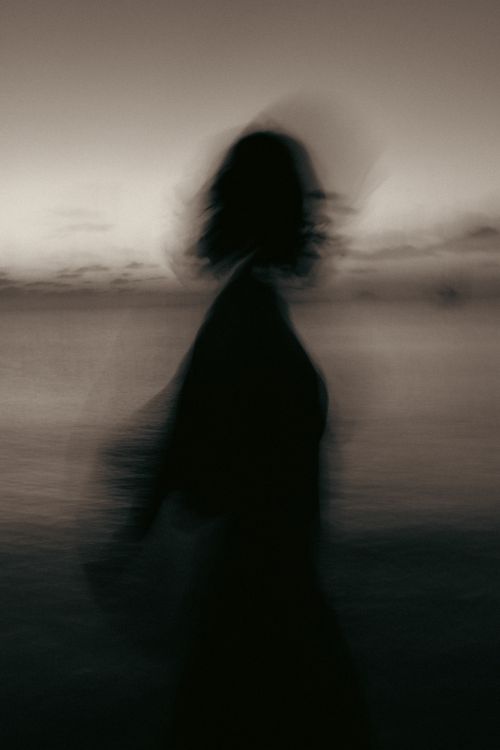 Free A mysterious silhouette in motion against a serene twilight backdrop, creating an artistic blur effect. Stock Photo