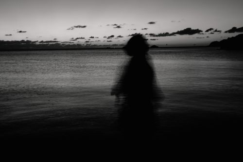 Free A mysterious silhouette moves along the shoreline during dusk, offering a tranquil and enigmatic atmosphere. Stock Photo