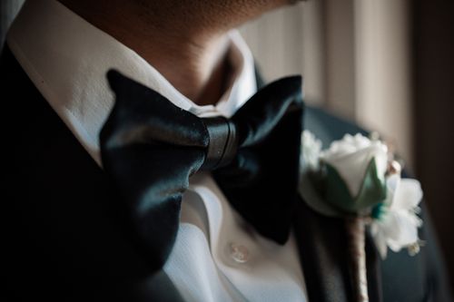 Free Close-up of a black bow tie and boutonniere on a groom's tuxedo at a wedding. Stock Photo
