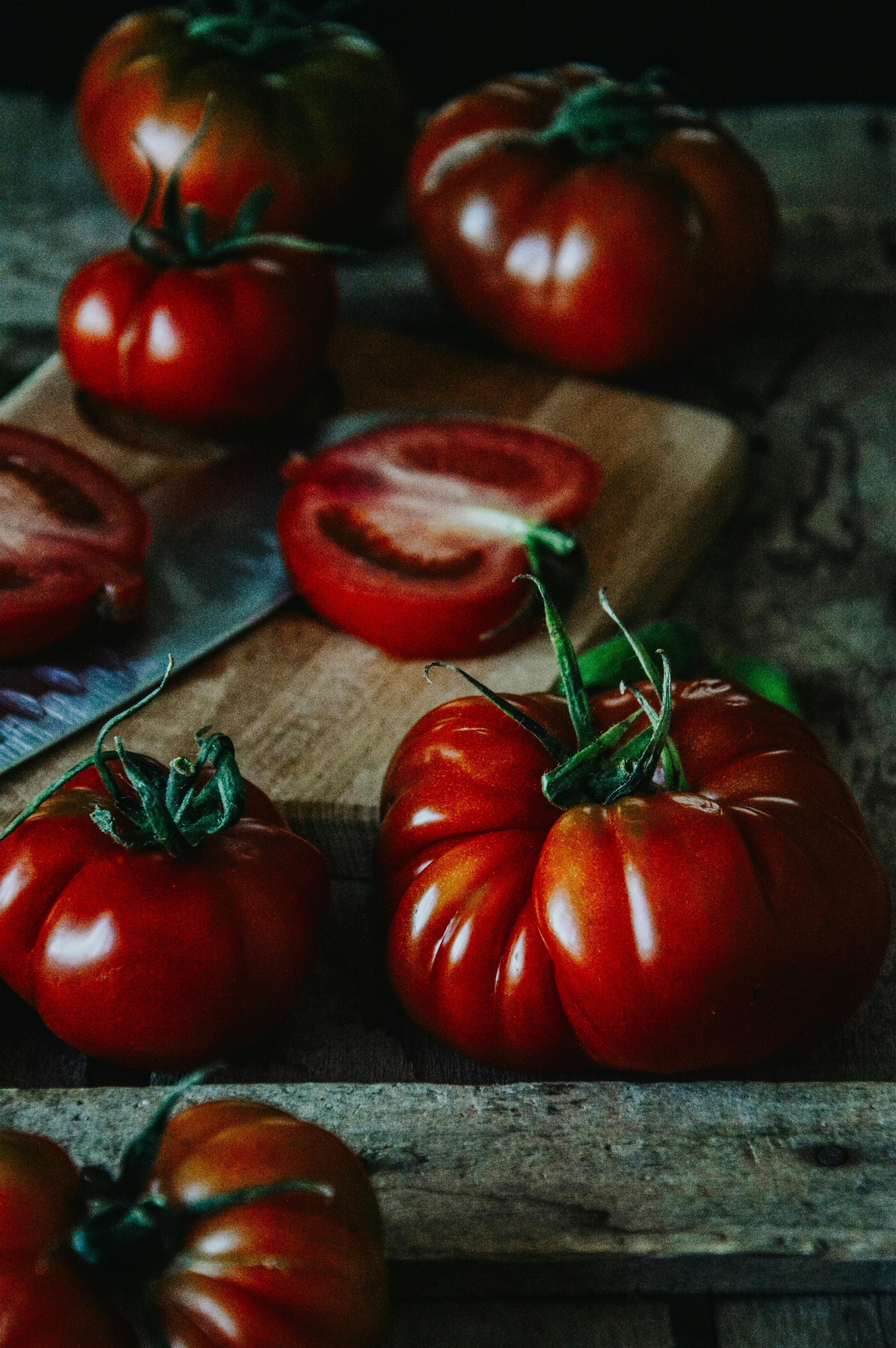 Mixed heirloom tomatoes on a wooden table showing different shapes and colours