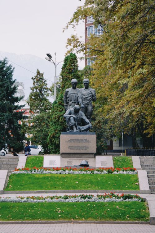 Free A war memorial statue surrounded by green in an urban Almaty park. Stock Photo