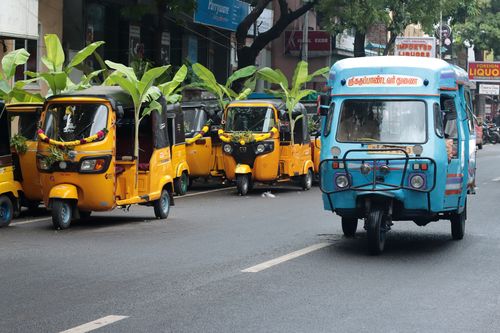 Free Colorful auto rickshaws adorned with decorations on a bustling street in Puducherry, India. Stock Photo