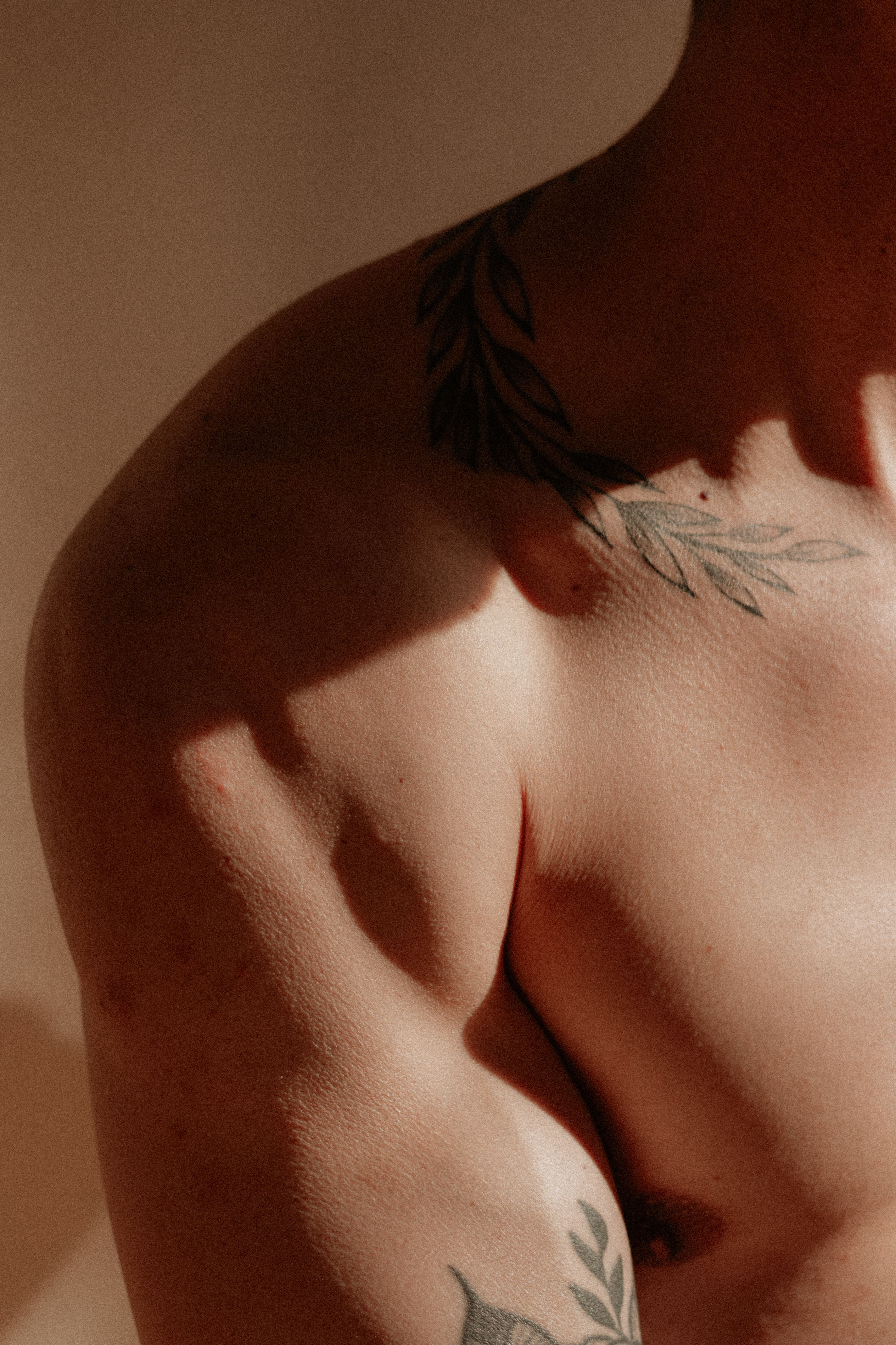 Close-up of a tattooed male bicep and shoulder in natural light, showcasing strength and body art.