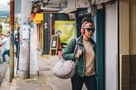 Woman walking on a busy street in San José, Costa Rica with headphones on.