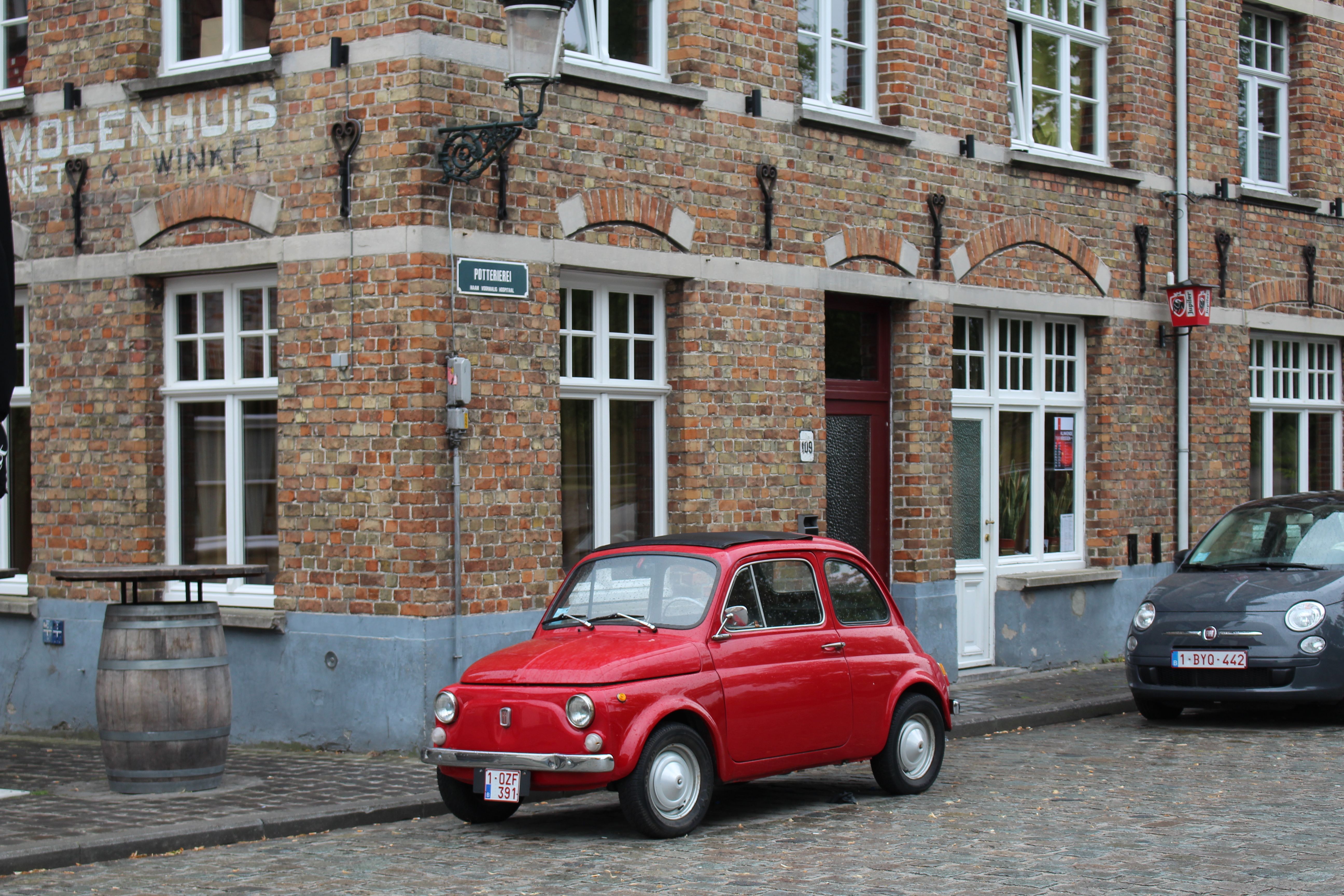 Vintage Red Fiat Car on Brugge Cobbled Street · Free Stock Photo