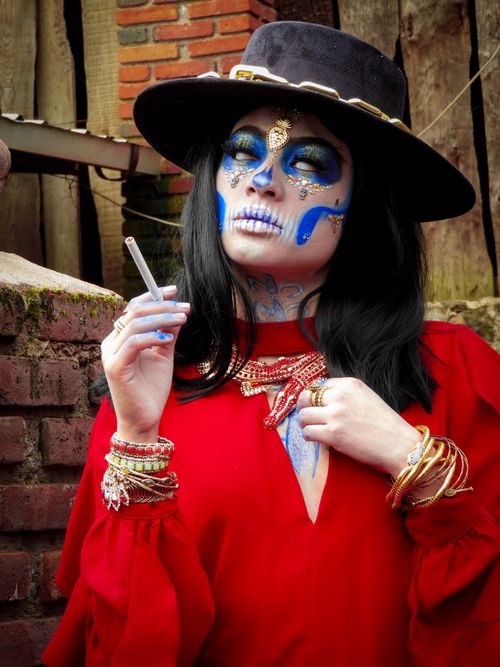 Free Colorful Day of the Dead Catrina with intricate makeup and vibrant outfit, celebrating Mexican tradition outdoors. Stock Photo