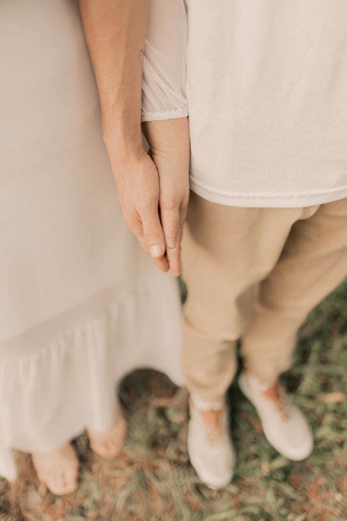 Free Close-up of a couple holding hands outdoors, symbolizing love and connection. Stock Photo