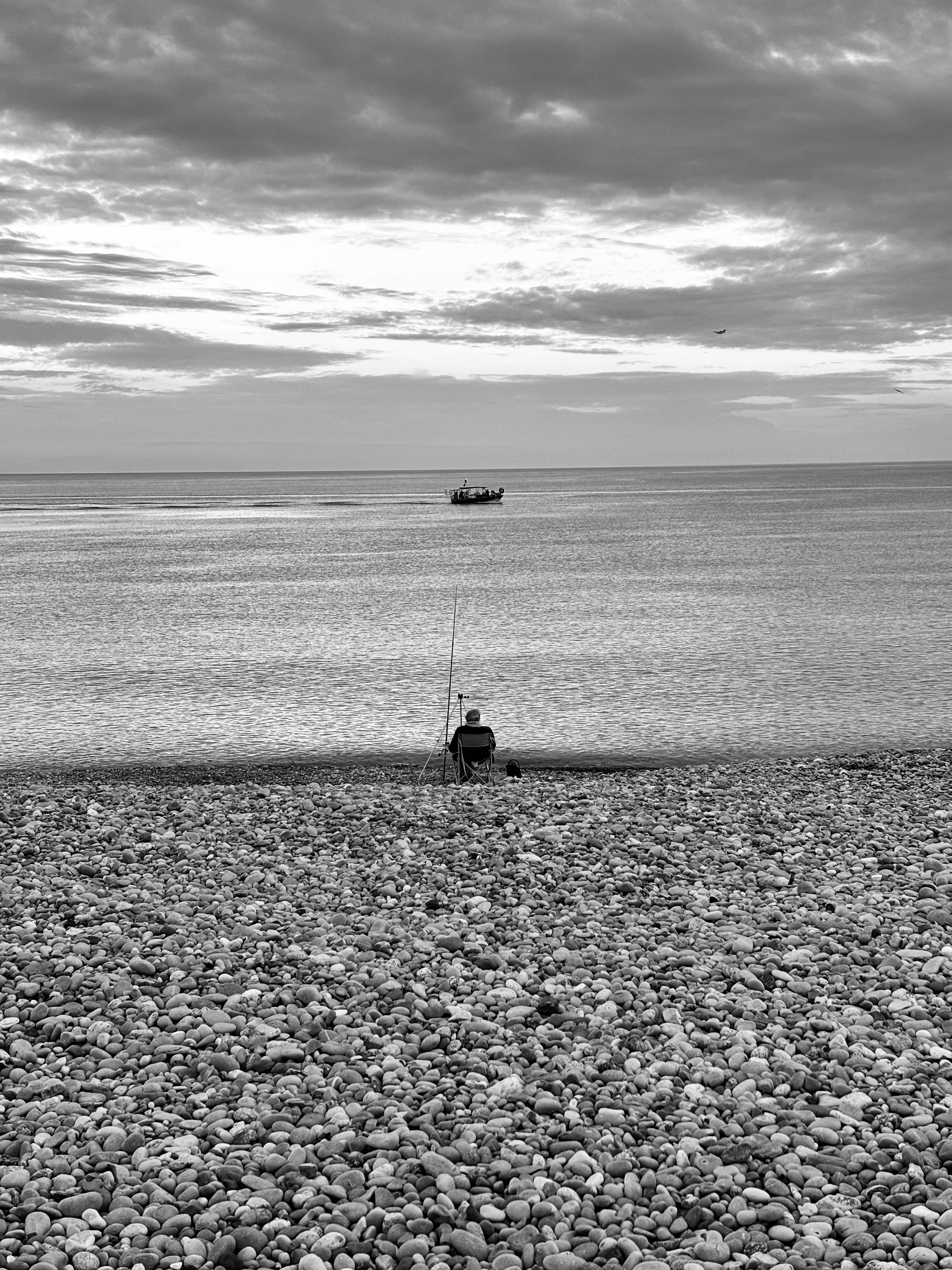 Solitary Fisherman on Pebble Beach at Dawn · Free Stock Photo