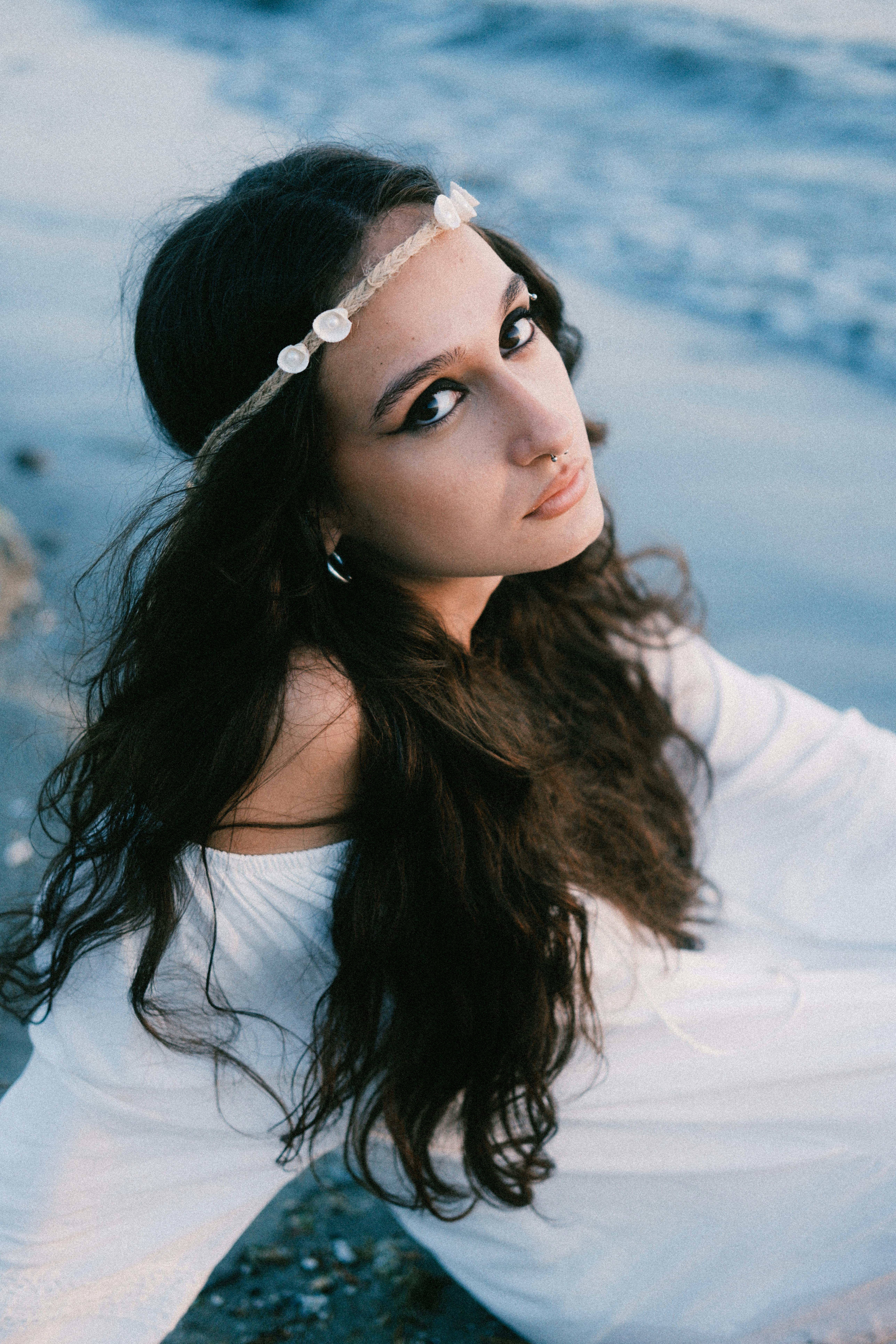 Serene portrait of a woman with a bohemian style by the ocean.