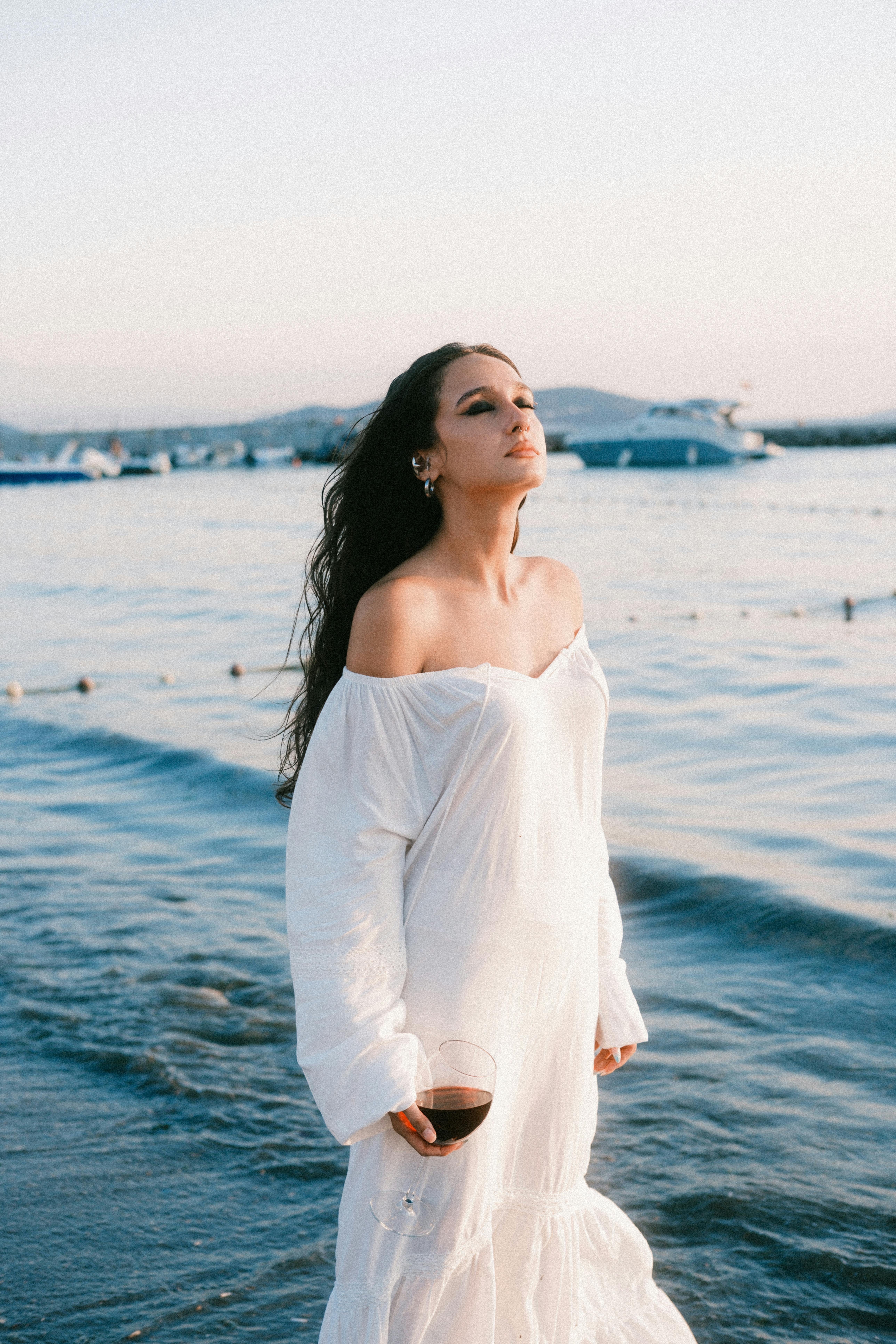 Woman in white dress relaxing by the sea