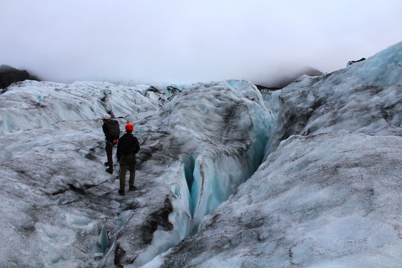 Two figures crossing a glacial landscape — photo by Brianna Eisman on Pexels