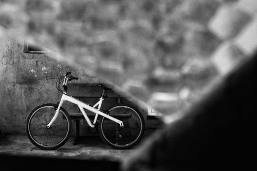 Free Stylish black and white photo of a bicycle leaning against a wall with creative framing. Stock Photo