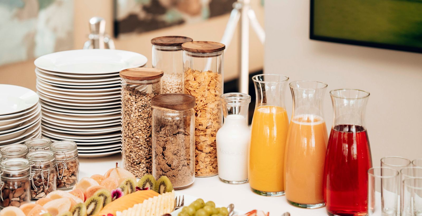 A hotel breakfast buffet spread of juices, cereals, and pastries