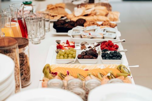 Free Colorful breakfast buffet featuring fresh fruits, pastries, and juices. Ideal for healthy and delicious morning meals. Stock Photo
