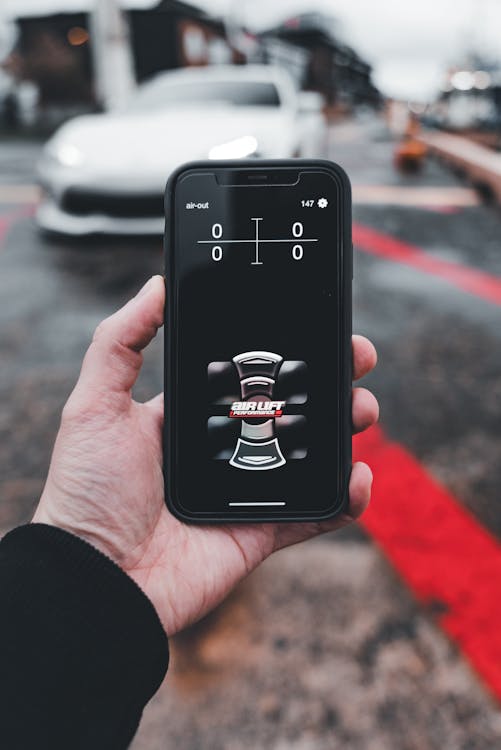 Smartphone with car control app in focus · Free Stock Photo