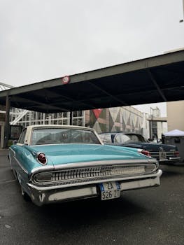 Classic turquoise car parked under urban canopy, showcasing retro style.