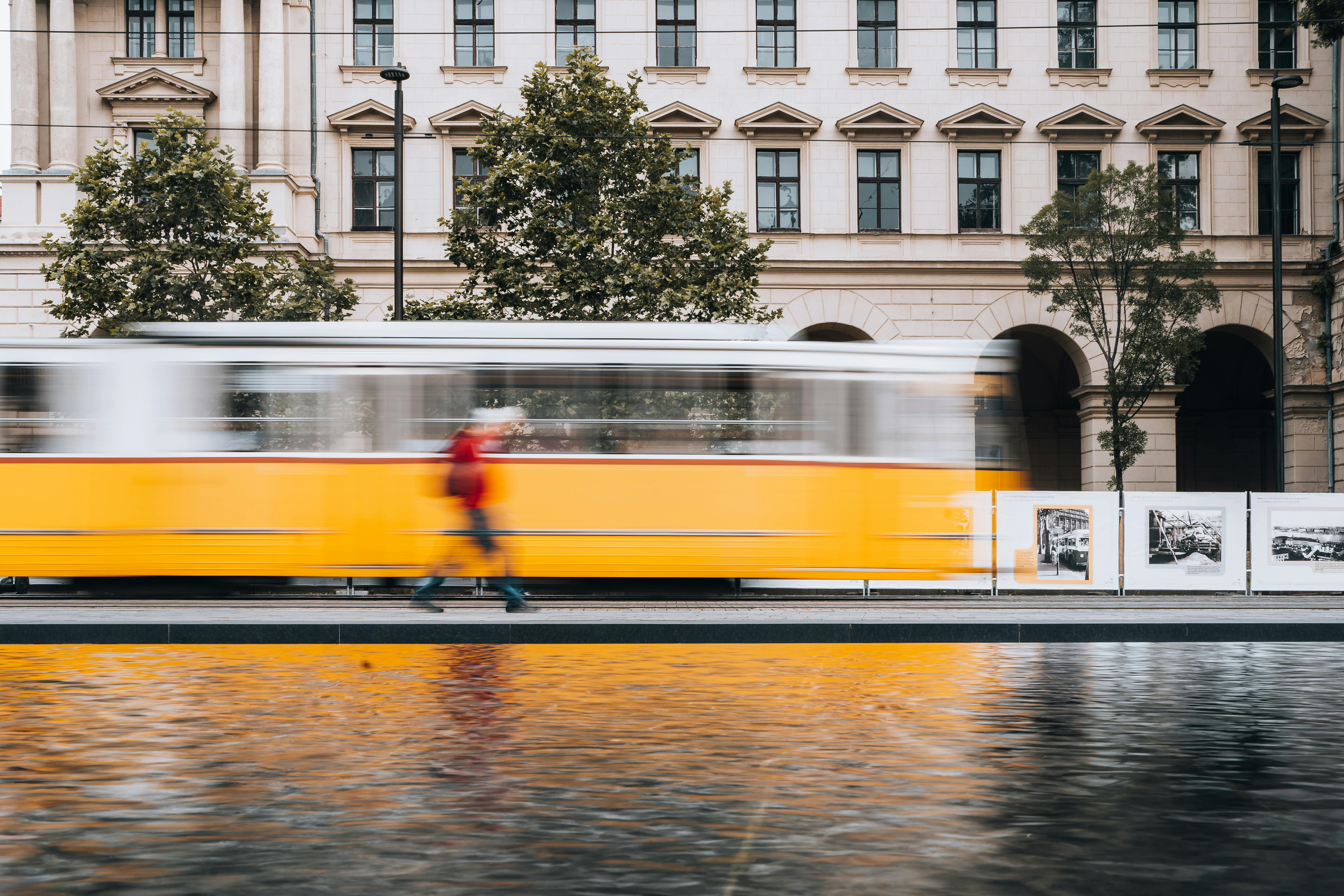Long exposure shot of a vibrant Berlin street featuring a yellow tram in motion.
