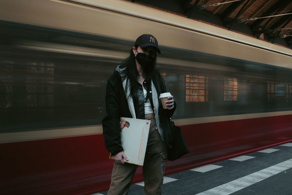 動いている列車とともにベルリン駅での女性のアーティスティックなロングエクスポージャー。