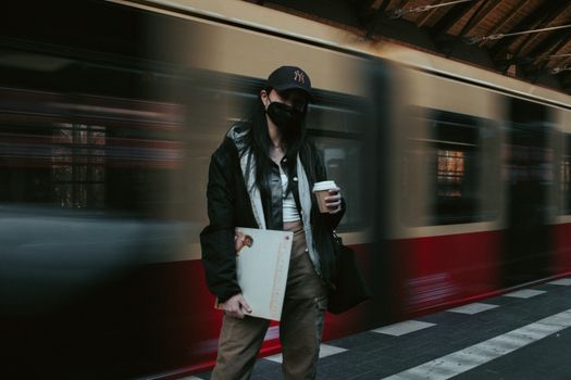 A commuter stands near a passing train in Berlin, capturing urban life.