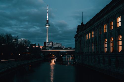 Free Night view of the Berlin TV Tower with reflections in the river. Iconic cityscape. Stock Photo
