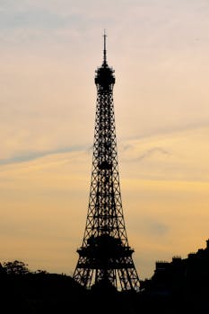 A breathtaking silhouette of the Eiffel Tower against a sunset sky in Paris, France.