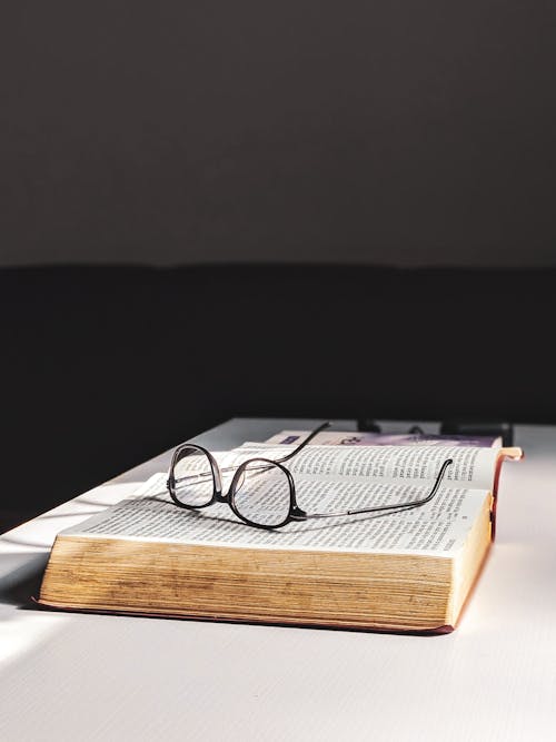 Eyeglasses on Top of an Opened Book 