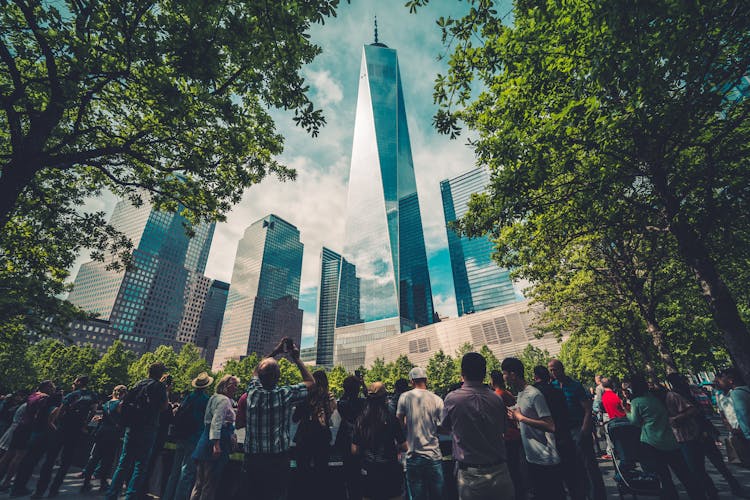 People Standing Across Glass Building