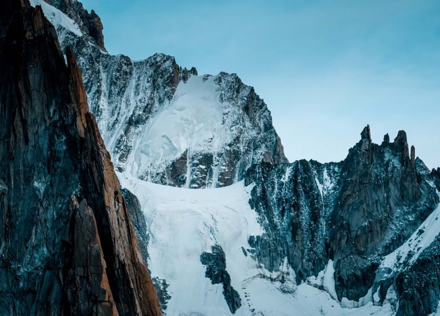 Breathtaking view of a snowy mountain range with jagged peaks under a clear blue sky.