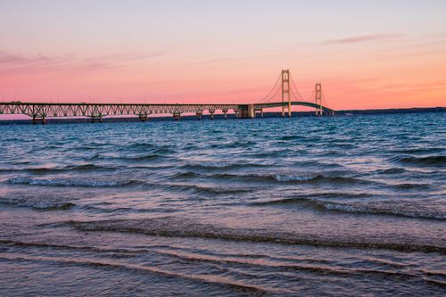 Free Stunning view of Mackinac Bridge at sunset with vibrant skies and serene waters. Stock Photo