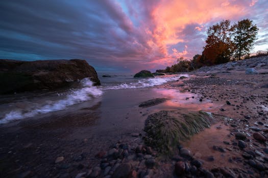 Capture of a vibrant autumn sunset over a rocky beach with colorful skies.