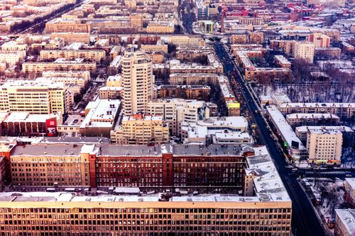 Free Explore a vibrant cityscape with snow-dusted rooftops and bustling streets from above. Stock Photo