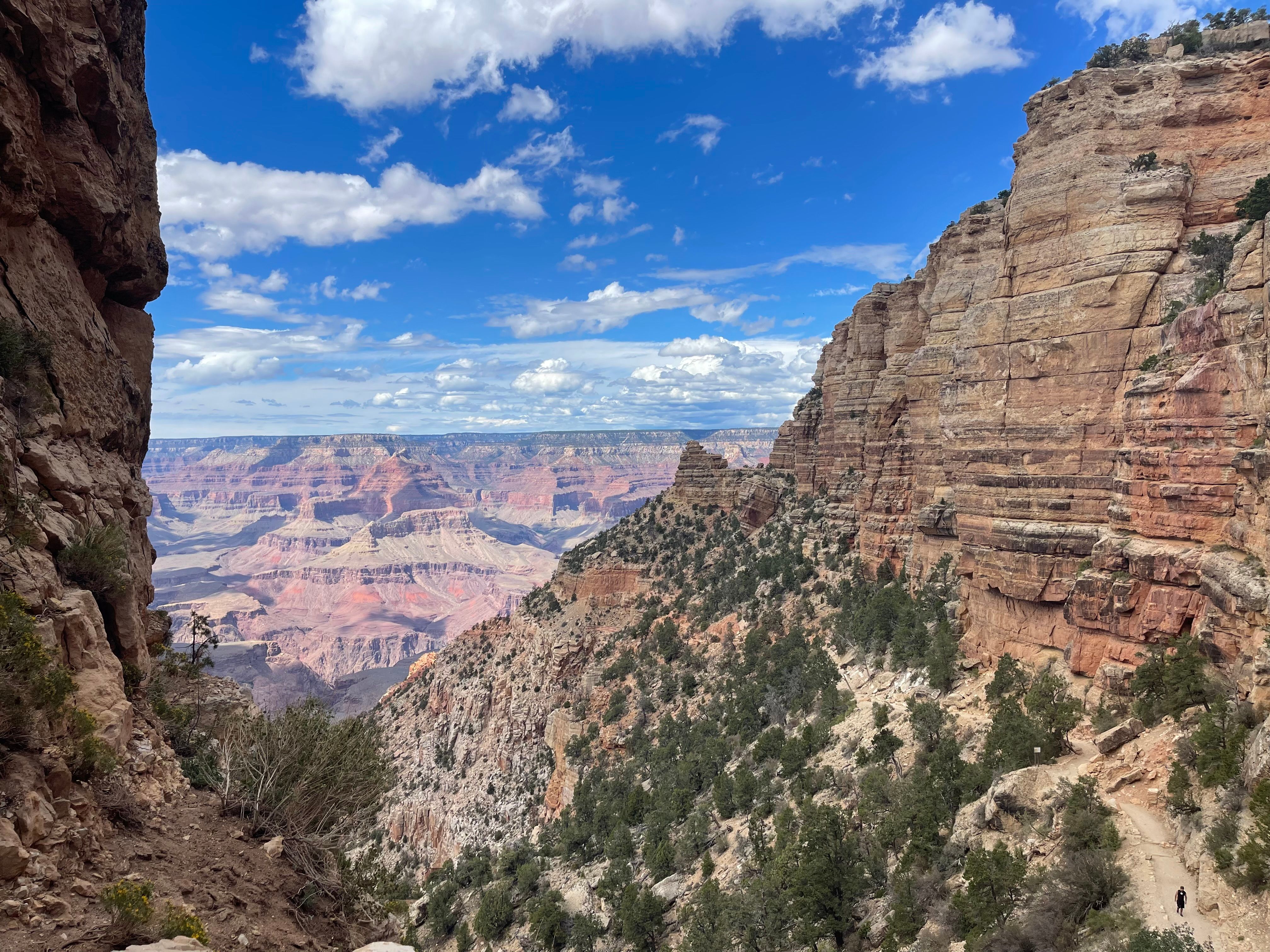 Stunning aerial view of the Grand Canyon's layered rock formations under a vibrant blue sky.