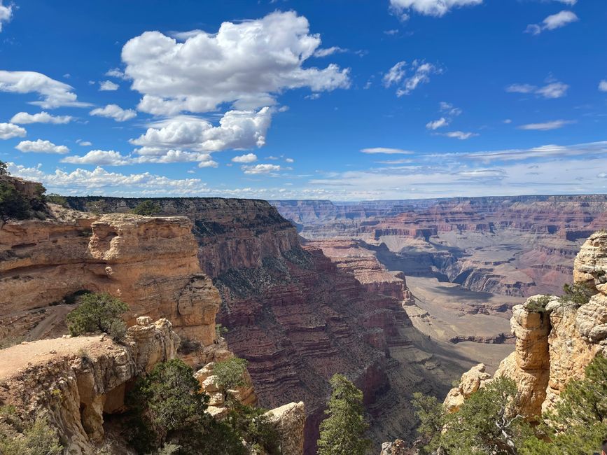 Breathtaking vista of Grand Canyon's unique rock formations and expansive desert landscape under a bright blue sky