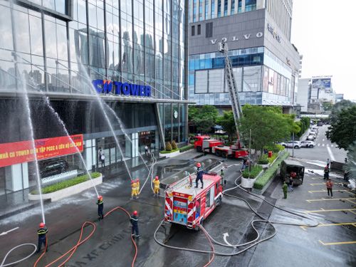 Free Firefighters conducting a drill with trucks and hoses at a high-rise office building. Stock Photo