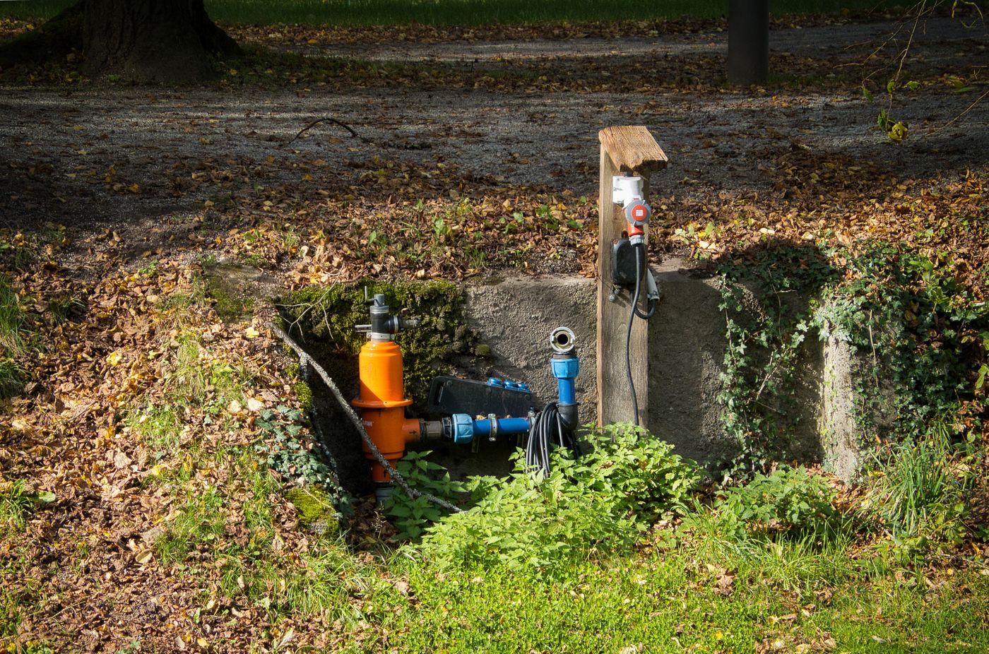 A water pipe system surrounded by autumn leaves in a park