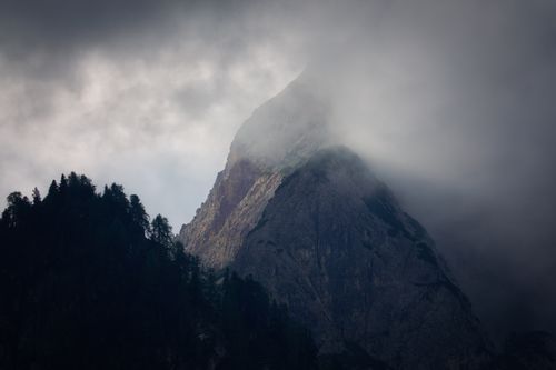 Free A striking mountain peak in Trentino-Südtirol, Italy, partially obscured by fog, creating a mysterious atmosphere. Stock Photo